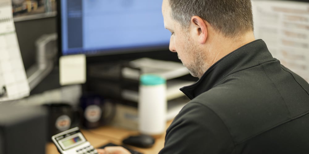 Man-using-calculator-at-desk